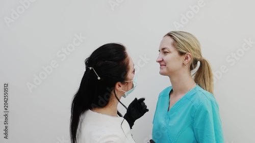 A female doctor, a professional cosmetologist, and a client are very happy after a procedure at a cosmetology clinic