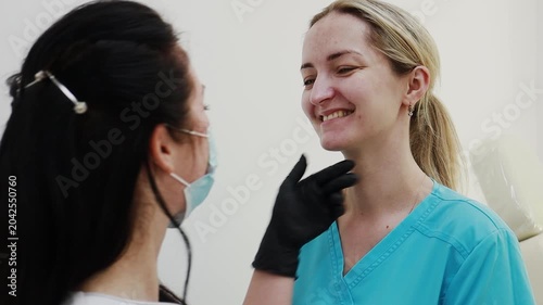 A female doctor, a professional cosmetologist, and a client are very happy after a procedure at a cosmetology clinic