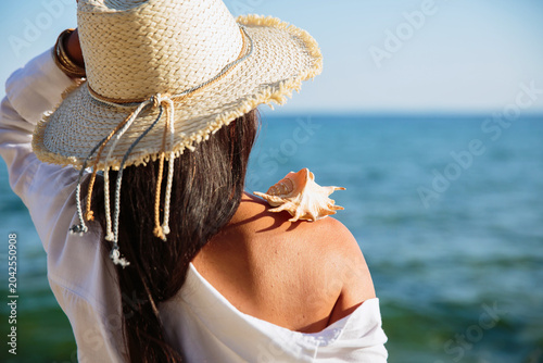 close detail of seashell on woman shoulder by ocean sunlight texture summer travel and sensory coastal lifestyle