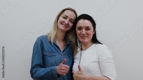 A female doctor, a professional cosmetologist, and a client are very happy after a procedure at a cosmetology clinic