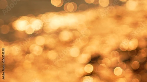 Water Golden Bokeh, shimmering abstract reflections on liquid surface at sunset, peaceful dreamlike scene