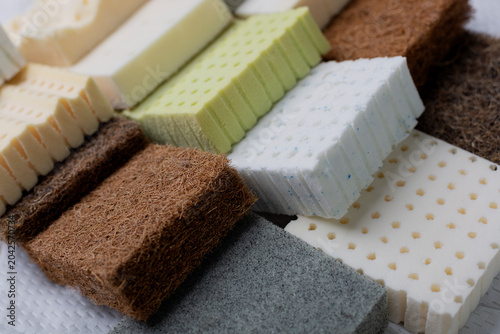 Foto Close-up of stacked mattress material samples, including firm coconut coir layers and soft latex foam