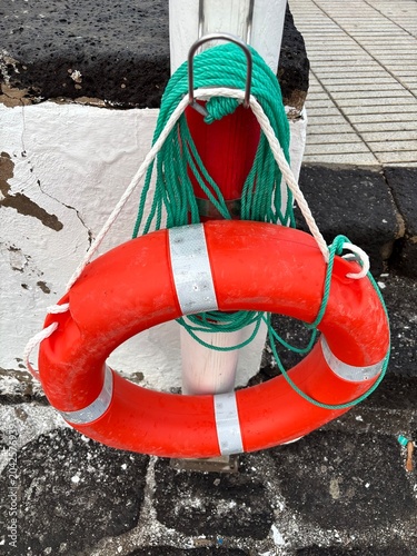 Rettungsring in orange mit grünem Seil an der Promenade von Arrecife, Lanzarote
