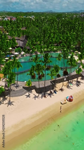 Aerial view of crystal water on the seashore, Mauritius with palm trees and living reef around the island