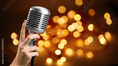 Hand holding a retro microphone on background