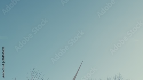 Wind turbine blades spinning against a clear sky