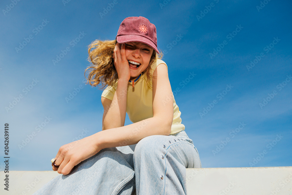 © BONNINSTUDIO/Stocksy - Blonde woman laughing enjoying sunny day outdoors