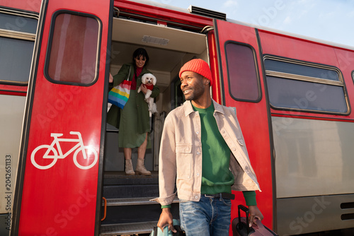 Two People and a Dog Arrive at a Train Station