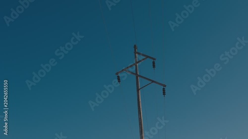 Wooden power pole with wires against blue sky