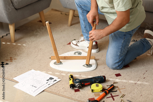 Young man assembling small ...