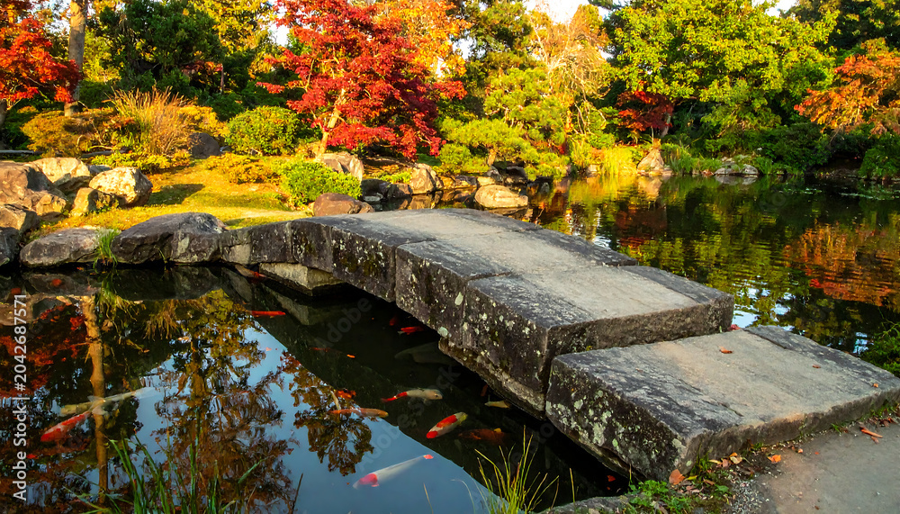 Naklejka premium Beautiful stone bridge in serene garden setting.