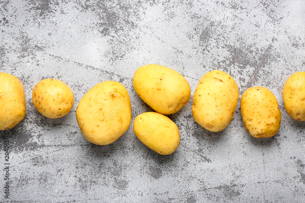 Naklejka premium Raw baby potatoes on grey background