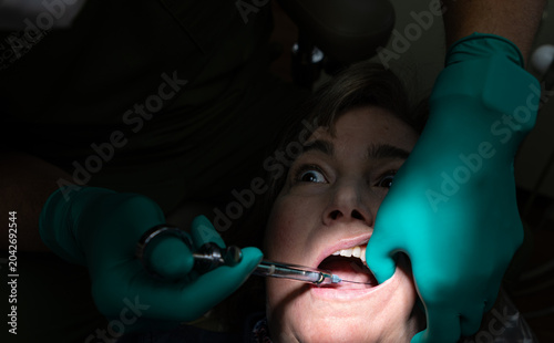 Canvas Print Patient receiving a local anesthetic injection prior to root canal treatment in a dental clinic