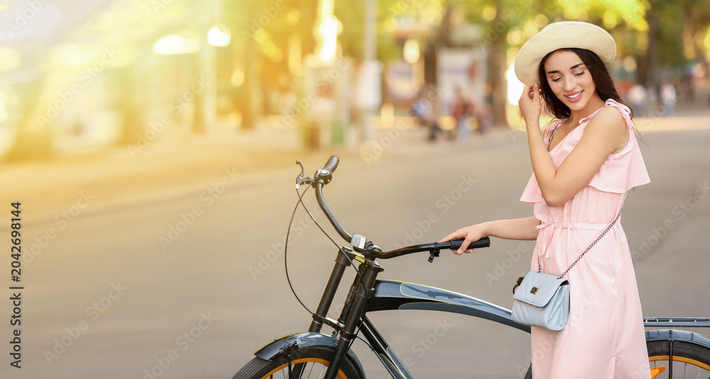 Obraz premium Beautiful young woman with bicycle outdoors