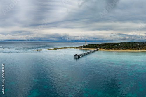 Dark storm front over coastal headland and calm blue sea