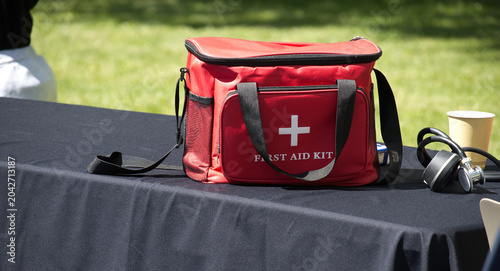 Red First Aid Kit On Table At Outdoor Event For Medical Emergency And Safety Preparedness