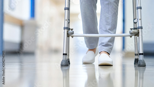 An individual uses a walker for support while recovering in a hospital setting, showcasing resilience and determination.