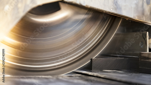 Close-up of a spinning saw blade, showcasing precision and power in industrial machinery, highlighting craftsmanship in manufacturing.
