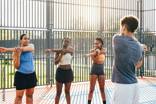 Group workout stretching at outdoor sports court