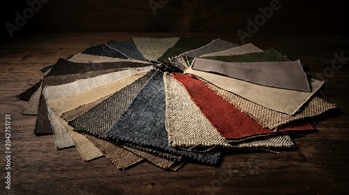 Collection of assorted fabric swatches arranged in a circular fan on a rustic wooden table