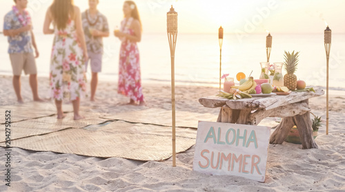 Aloha summer beach luau party setup with tiki torches and fruit