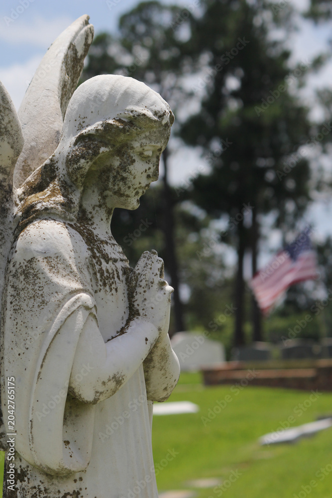 Obraz premium Old Angel Statue With American Flag in Background Rural East Texas Cemetery