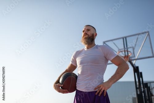 Self assured streetball player against blue sky
