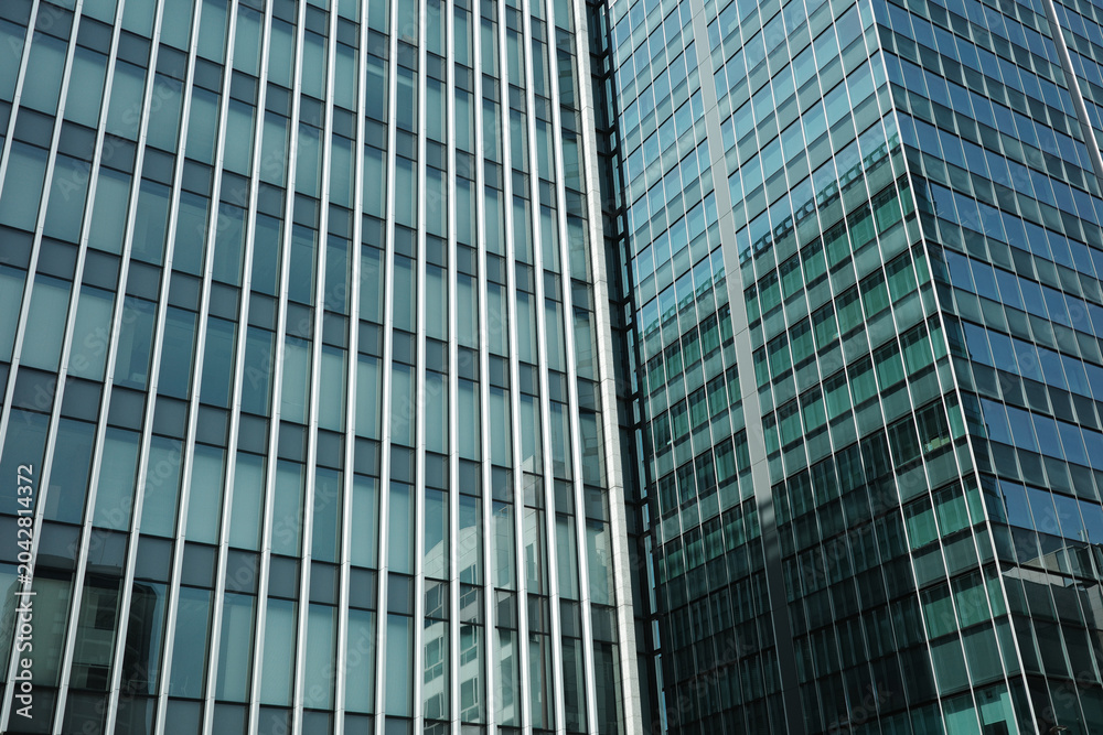 Obraz premium Modern glass facade of corporate office buildings with reflections background. global business, financial districts, corporate success, urban development, and contemporary office architecture.