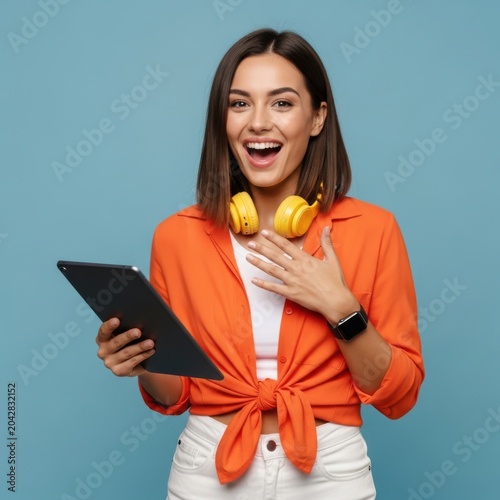 Smiling woman holding tablet and headphones