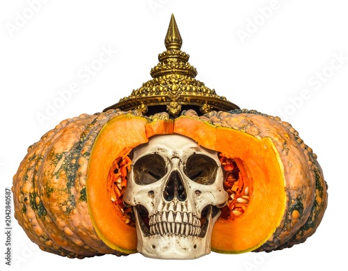 A human skull inside a carved pumpkin with a golden crown on top