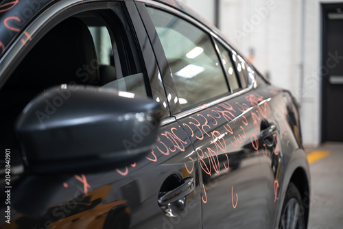 Car with dent marks in to Preparing process of Repairing Hail Damage in car body shop. Close up