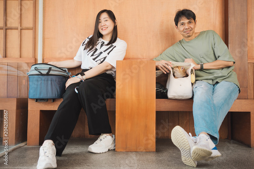 asian couple smile and happy during play with they cat in coffee shop