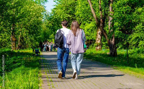 A guy and a girl walk along the path in the city Park