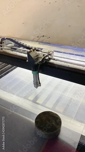 The head of the laser machine cuts acrylic sheets in the workshop