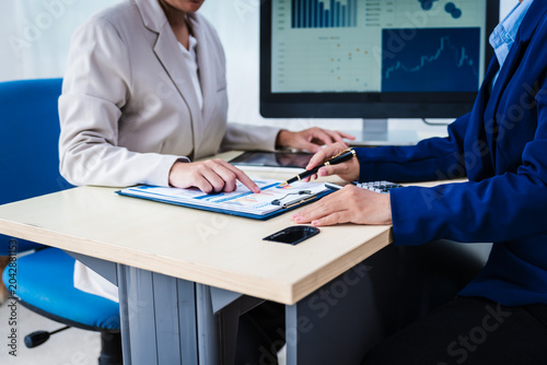 Fotografie Experienced Asian woman trains new employee in office work, teaching secretarial duties, document management, assistant manager responsibilities