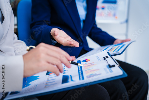 Tableau sur toile Experienced Asian woman trains new employee in office work, teaching secretarial duties, document management, assistant manager responsibilities