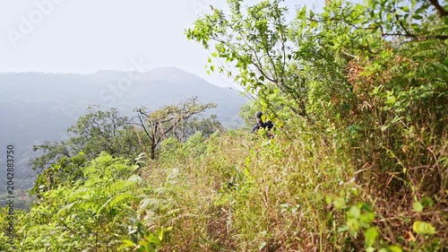 Dolly view of adventurers trekking across hilly landscape on an outdoor nature trail