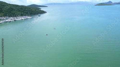 Aerial View of Rowing Race Competition in Turquoise Sea Near Coastal Hills. High quality 4k footage