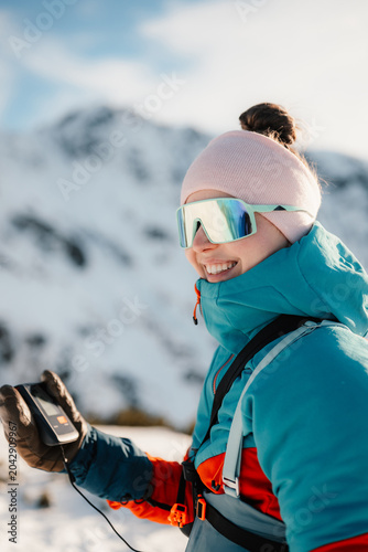 Ski alpinist in the mountains. Ski touring in alpine landscape with holding a modern avalanche beacon in his hands. Off piste skier in Low Tatras, slovakia