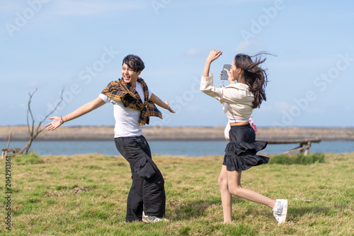 Young Woman Taking Photo of Happy Boyfriend Outdoors