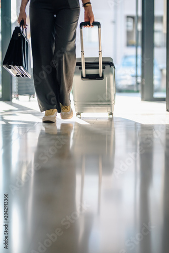 Quadro su tela Business traveler walking through airport terminal carrying luggage