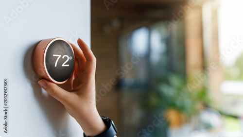 Hand Adjusting Smart Thermostat in Modern Home for Comfortable E