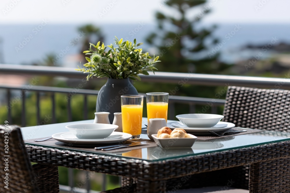 Fototapeta premium Breakfast on balcony with ocean view seaside morning outdoor dining table juice