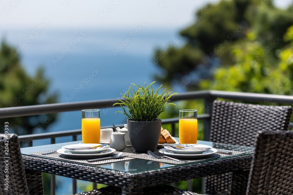 Fototapeta premium Breakfast for two on balcony with ocean view morning table outdoor terrace resort