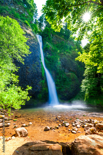 Sunlit Waterfall in Lush Oregon Forest with Starburst Light