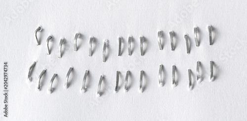 Fotografie Staples pushed into a paper, metal office staple needles
