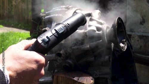 cleaning and washing with a steam cleaner of an old manual transmission from a front-wheel drive car for repair