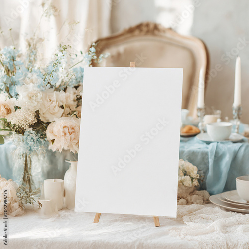 White vertical blank invitation mockup, vintage French style table in the background, old aristocratic coastal style white and blue color palette