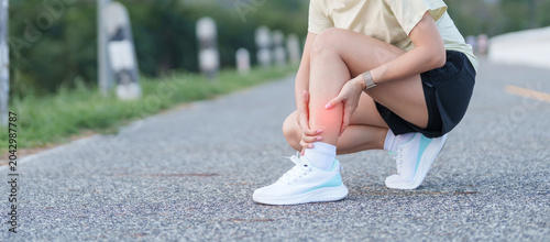Fotografie Young adult woman runner suffering from acute calf muscle pull and leg ache during running workout