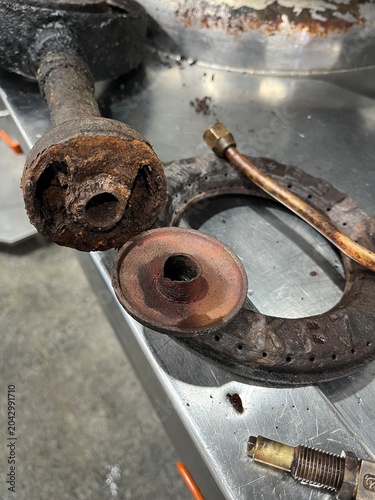 Close-up of industrial gas burner components showing corrosion, wear, and deterioration after long-term operation. Image highlighting equipment inspection, preventive maintenance, asset management, an